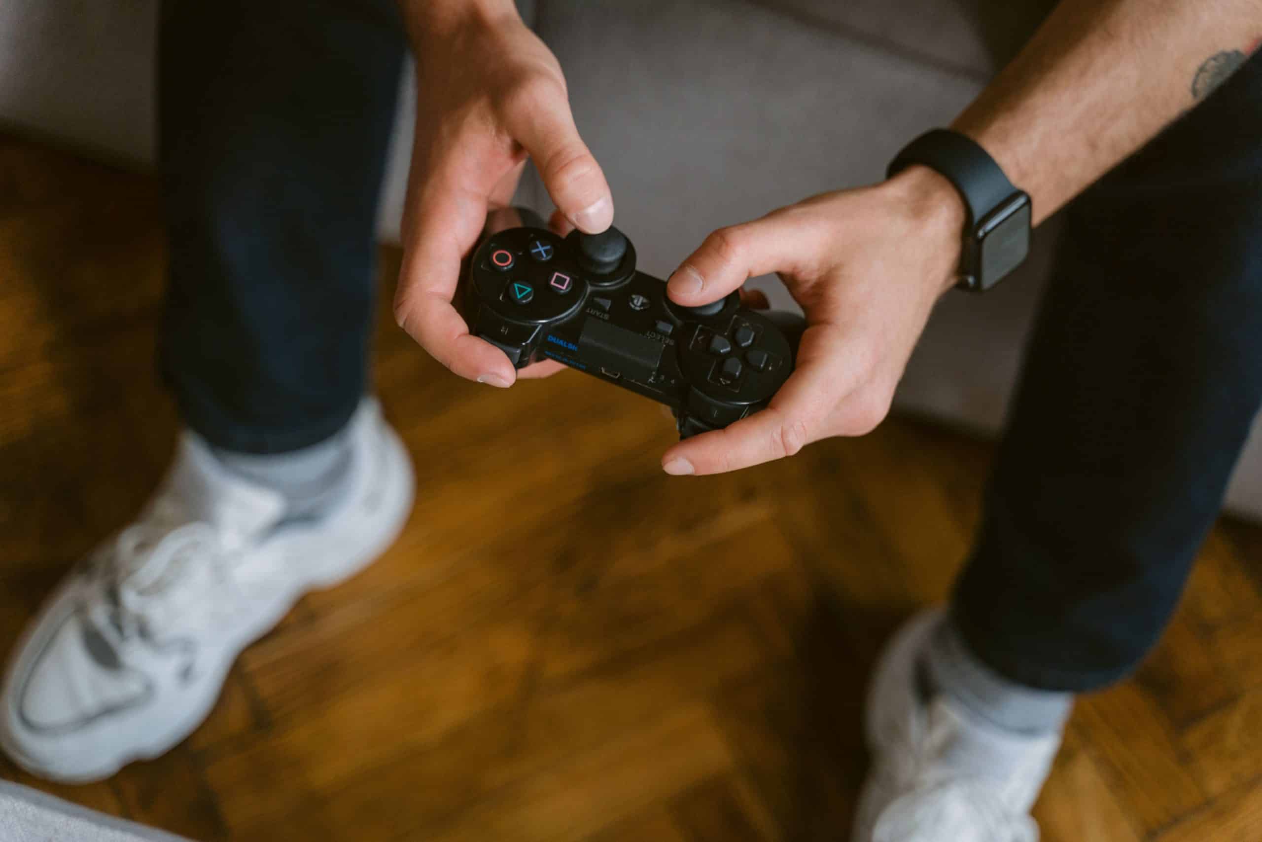 Person holding a video game controller while participating in a gaming or esports activity.